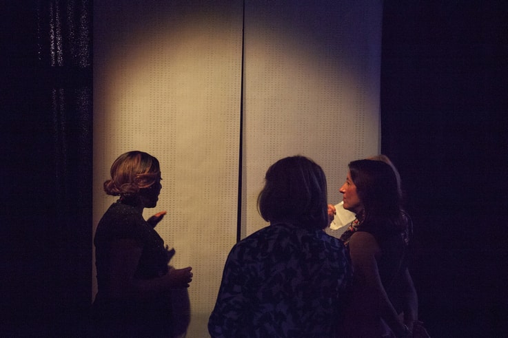 An Artist explains her work to three gallery viewers. 